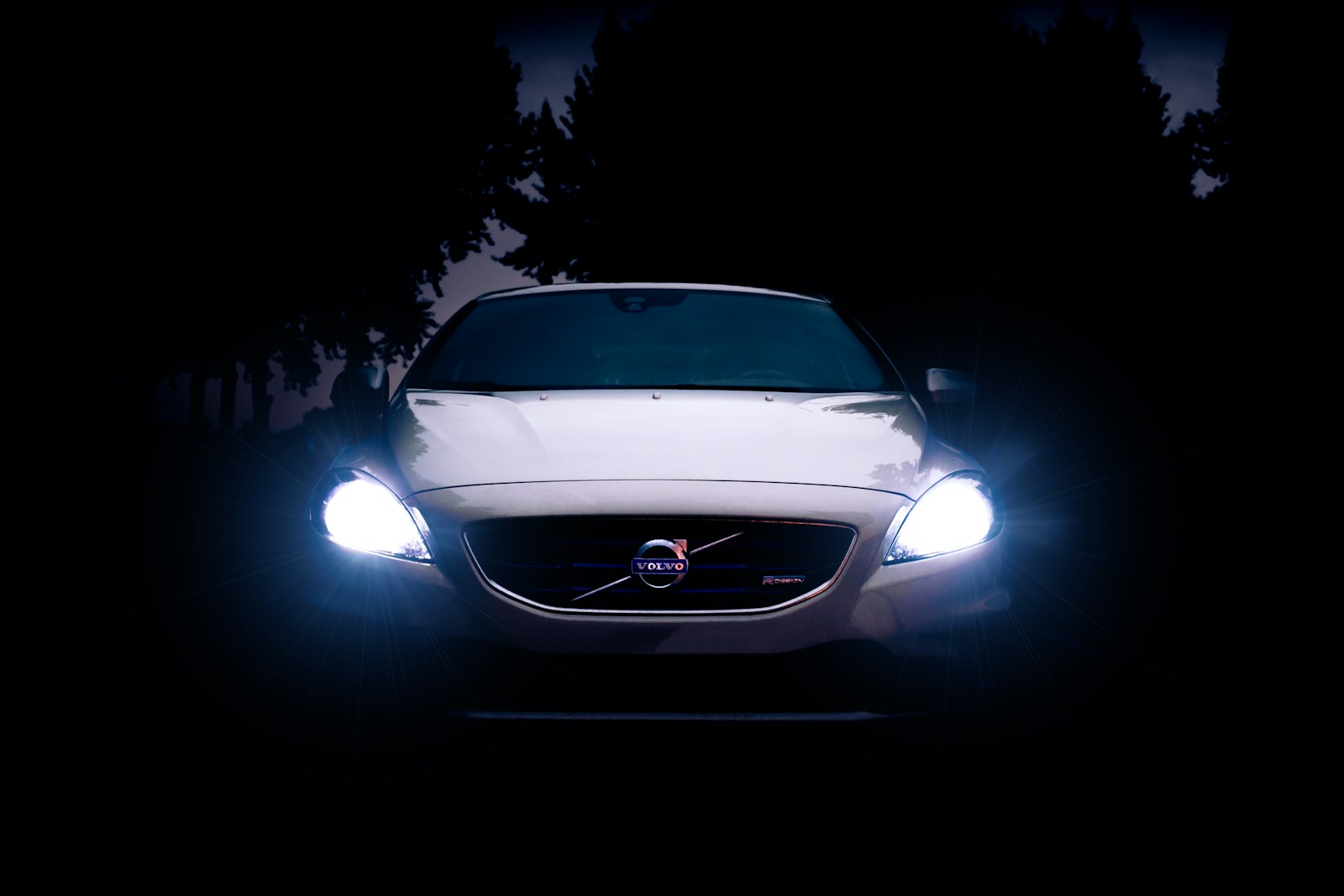 silver Volvo car with headlights on during night